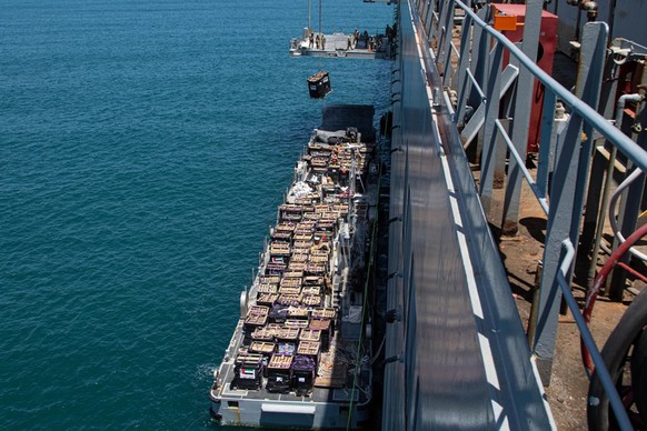 Humanitarian aid is lifted by a crane operated by soldiers assigned to the 7th Transportation Brigade (Expeditionary) from a Navy causeway at the Port of Ashdod, Israel, May 14, 2024. These soldiers a ...
