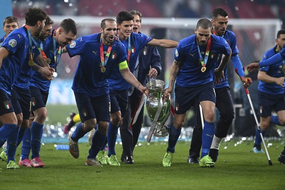 Italy&#039;s Giorgio Chiellini, center left, and Italy&#039;s Leonardo Bonucci hold up the trophy after the final of the Euro 2020 soccer final match between England and Italy at Wembley stadium in Lo ...