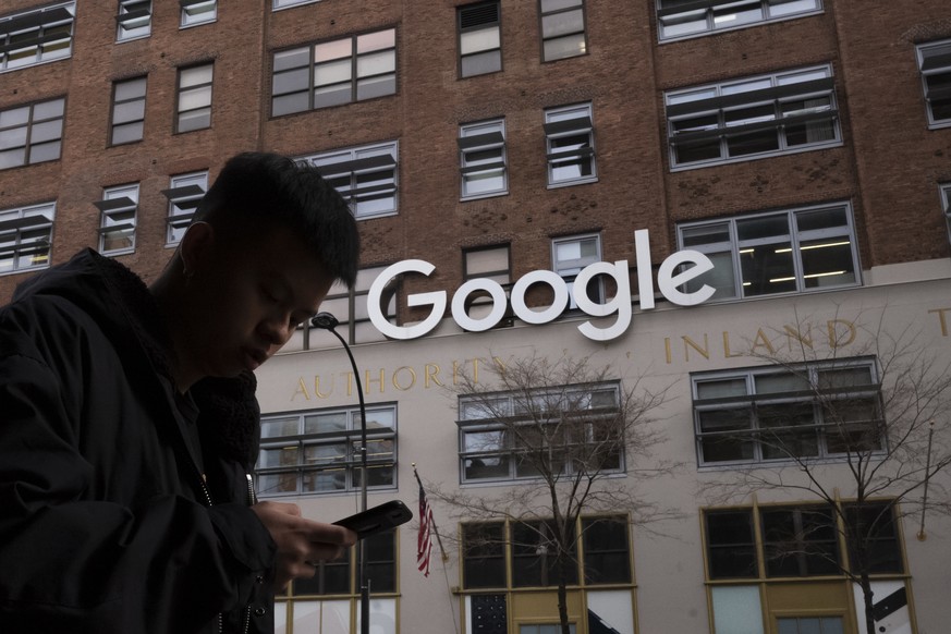 FILE - In this file photo dated Monday, Dec. 17, 2018, a man using a mobile phone walks past Google offices in New York. Google is appealing a 500 million euro ($591 million) fine, Wednesday, Sept. 1, ...