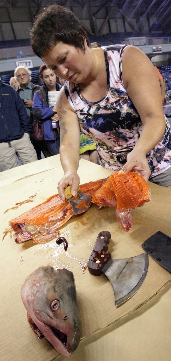 July 19, 2013 - Fairbanks, AK, U.S. - Eric Engman/News-Miner.Nicole Johnston, originally from Nome, demonstrates the fish-cutting technique used for hanging fish fillets to dry during the World Eskimo ...