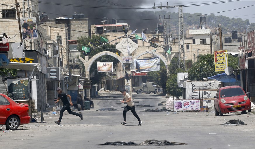 Des Palestiniens se mettent à l'abri lors d'une frappe israélienne à Jénine, en Cisjordanie, lundi.