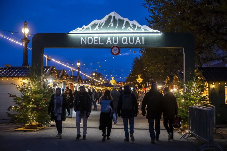 Des visiteurs déambulent entre les chalets et sous les decorations de Noel au Quai, le marché de Noël sur le quai du Mont-Blanc, ce jeudi 20 novembre 2025 à Genève.