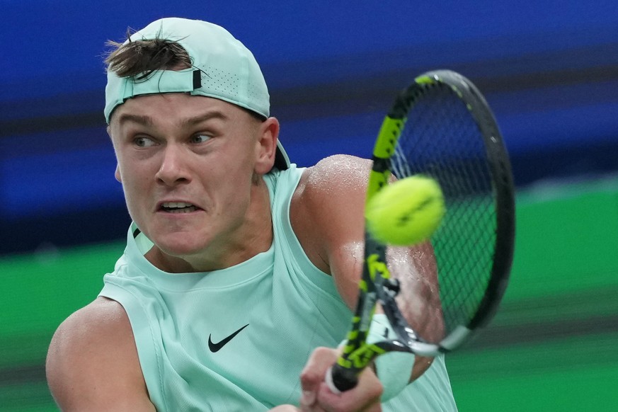 Holger Rune, of Denmark plays a backhand return to Giovanni Mpetshi Perricard, of France during the men&#039;s singles match of the Shanghai Masters tennis tournament at Qizhong Forest Sports City Ten ...