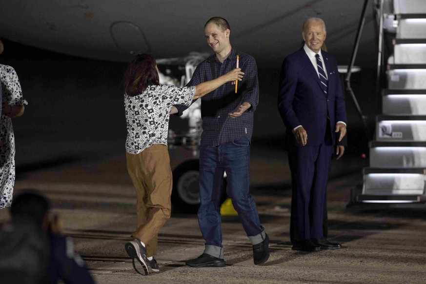 Evan Gershkovich retrouve ici sa mère sur le tarmac. Derrière lui se tient l'ancien président américain, Joe Biden.