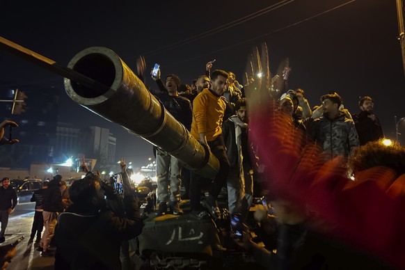 Syrians celebrate the arrival of opposition fighters in Damascus, Syria, Sunday Dec. 8, 2024. (AP Photo/Omar Sanadiki)