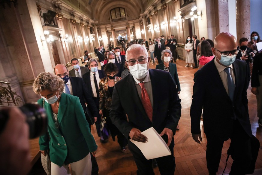 epa09549441 Portuguese Prime Minister Antonio Costa (C) flanked by the Minister of State and Finance, Joao Leao (R), after the Parliament rejected the State Budget proposal for 2022 (OE2022) in Lisbon ...