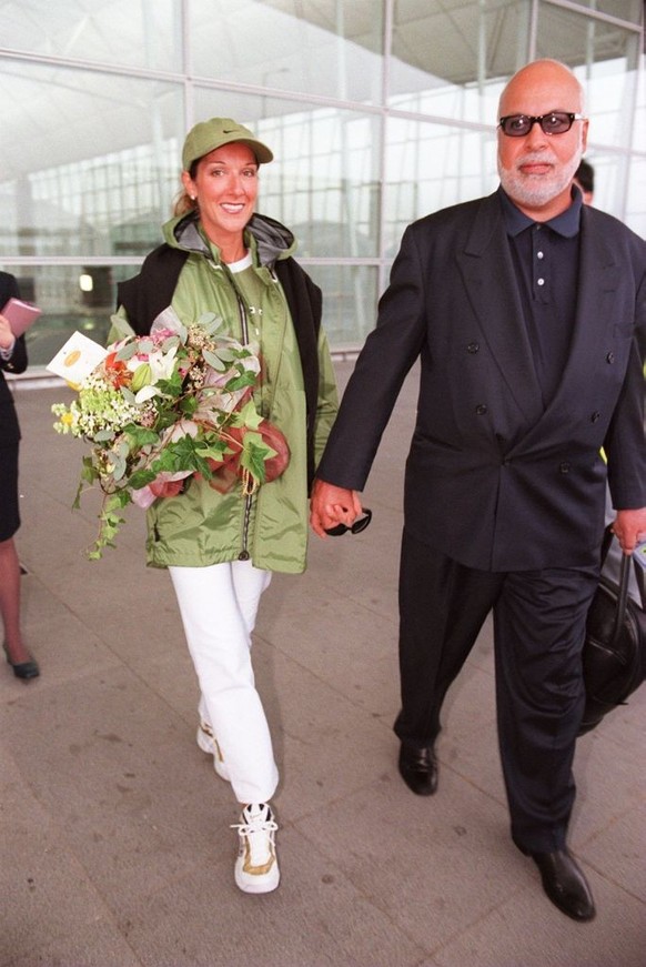 CELINE DION (LEFT) AND HER HUSBAND ARRIVE AT THE HONG KONG INTERNATIONAL AIRPORT. 23 January 1999 (Photo by ANTONY DICKSON/South China Morning Post via Getty Images)