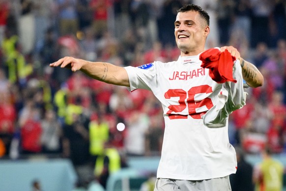 Switzerland's midfielder Granit Xhaka celebrates the victory and the qualification with the shirt of Switzerland's midfielder Ardon Jashari after the FIFA World Cup Qatar 2022 group G soccer match bet ...