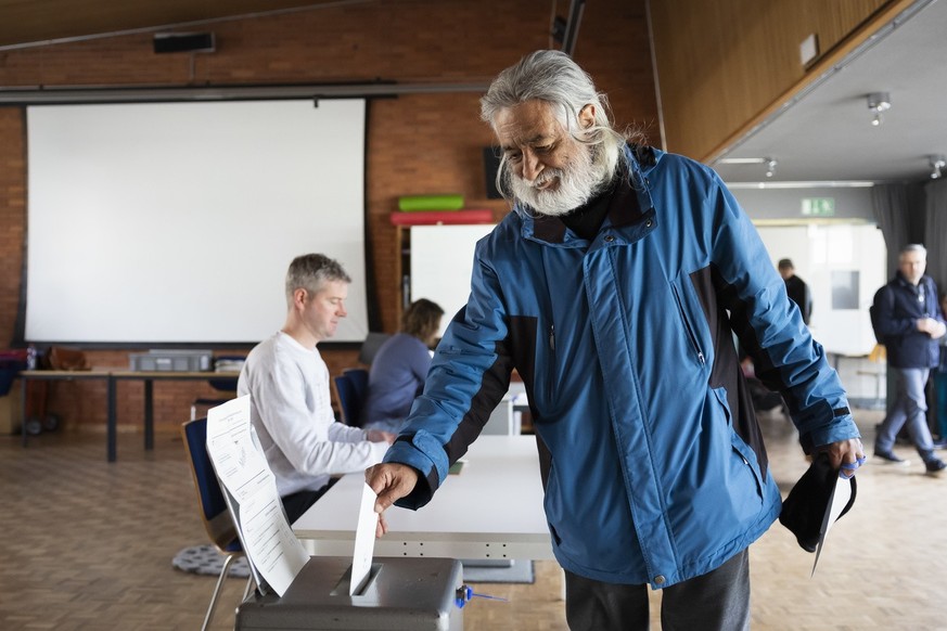 Ein Stimmbuerger wirft seinen Stimmzettel in die Urne, im Stimmlokal Schulhaus Hochfeld, am Samstag, 2. Maerz 2024 in Bern. Die Schweizer Buergerinnen und Buerger stimmen ueber die Renteninitiative un ...