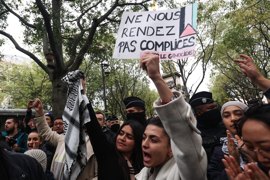Une femme brandit une pancarte lors d'une manifestation de soutien aux Palestiniens à Paris.