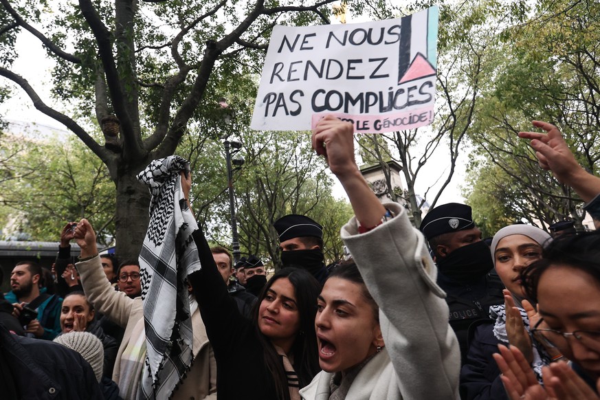 epa10945620 A protester holds a signboard reading &#039;Don&#039;t make us complicit, Stop the genocide&#039; during a demonstration to support Palestinians, at Place du Chatelet in Paris, France, 28  ...