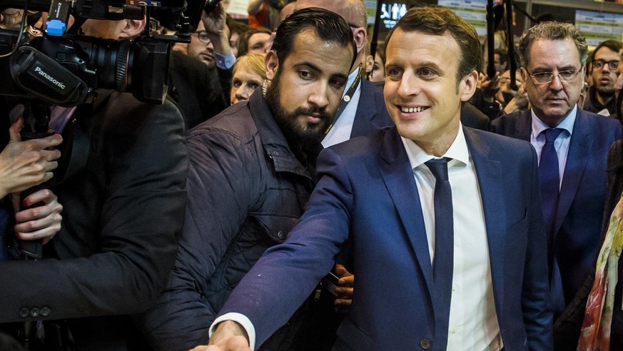 epa06907398 The then French presidential candidate Emmanuel Macron (C-R) of the &#039;En Marche&#039; political movement flanked by security staff Alexandre Benalla (C-L) visiting the International Ag ...