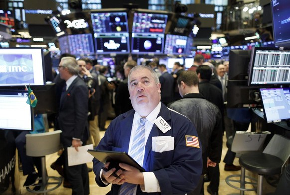 epa08289381 A trader looks at the Dow Jones industrial average on the floor of the New York Stock Exchange in New York, New York, USA, on 12 March 2020. Stocks around the world continued to lose value ...