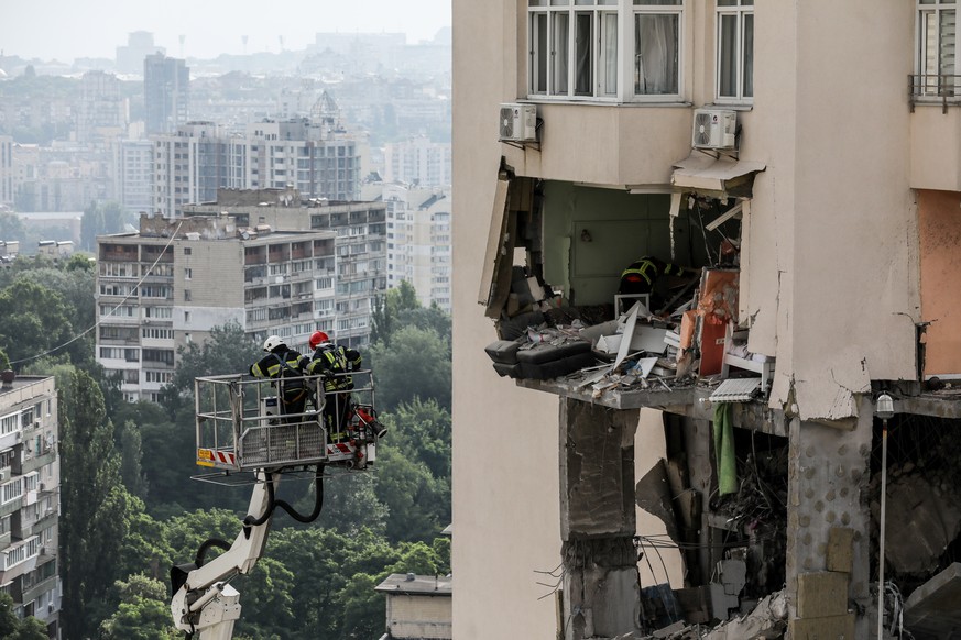 epa10709077 Rescue workers in action after an apartment block was damaged by rocket fragments in Kyiv (Kiev), Ukraine, 24 June 2023, amid the Russian invasion. At least three people were killed by roc ...