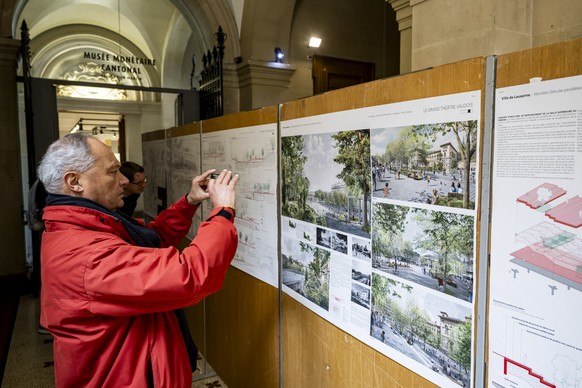 Des personnes regardent des plans de la place de la Riponne provenant du groupement d&#039;architectes autour du projet ILEX de Lyon, lors du concours d&#039;amenagement de la place de la Riponne le s ...