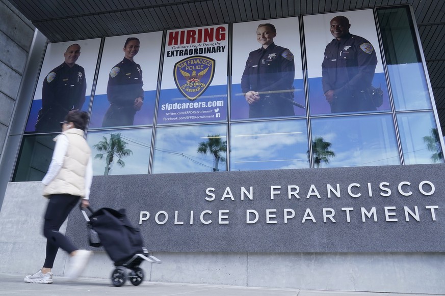 A pedestrian walks in front of a San Francisco Police Department advertisment outside police headquarters in San Francisco, Monday, Sept. 12, 2022. A woman whose DNA from a sexual assault case was use ...