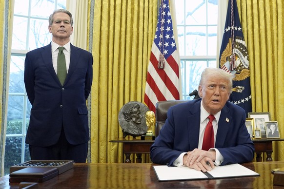FILE - President Donald Trump speaks as Treasury Secretary Scott Bessent listens as Trump prepares to sign an executive order in the Oval Office of the White House, Feb. 3, 2025, in Washington. (AP Ph ...