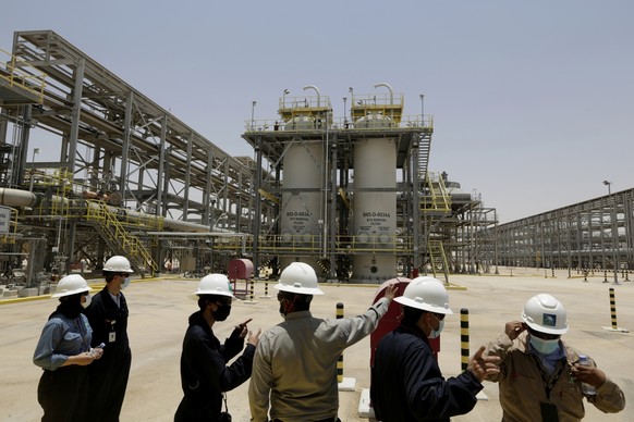 FILE - Saudi Aramco engineers and journalists look at the Hawiyah Natural Gas Liquids Recovery Plant in Hawiyah, in the Eastern Province of Saudi Arabia on June 28, 2021. Oil giant Saudi Aramco on Tue ...