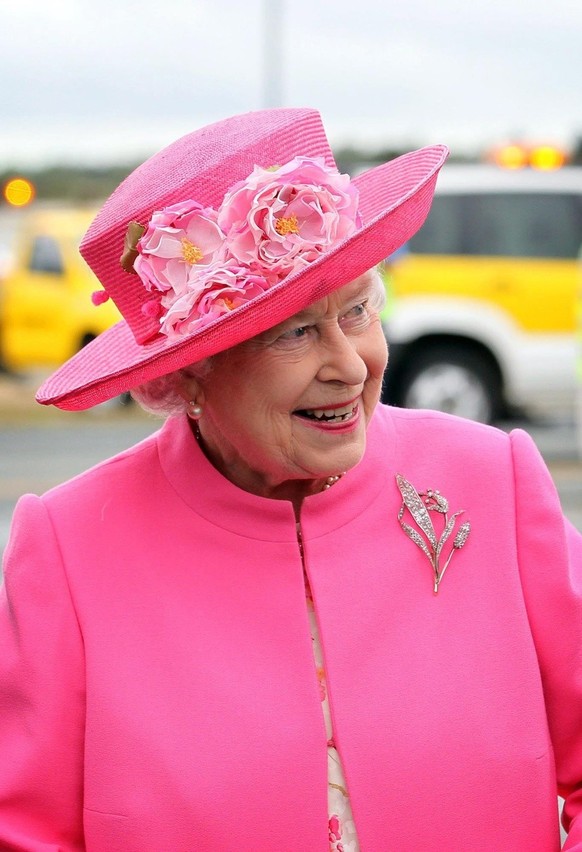 In matching pink hat and topcoat Britain&#039;s Queen Elizabeth II arrives with a smile at Perth International airport 26 October 2011 to attend the Commonwealth Heads of Government Summit as part of  ...