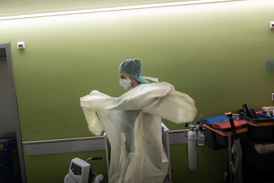 A doctor prepares to work with patients with Covid-19 and intubated patients at the Intensive Care Unit in the emergency room at the regional hospital La Carita in Locarno, Switzerland, April 2, 2020, ...