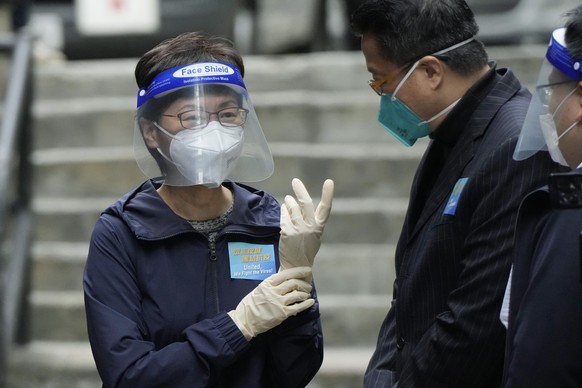 Hong Kong Chief Executive Carrie Lam, left, wears gloves before delivering package of coronavirus prevention materials to people during an anti-epidemic event in Hong Kong, Saturday, April 2, 2022. Hong Kong authorities on Saturday asked the entire population of more than 7.4 million people to voluntarily test themselves for COVID-19 at home for three days in a row starting next week. (AP Photo/Kin Cheung)
Carrie Lam