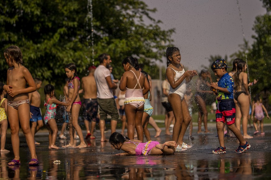 Children cool off in an urban beach at Madrid Rio park in Madrid, Spain, Wednesday, July 13, 2022. Weather forecasters say Spain is expected to have its second heat wave in less than a month and that  ...
