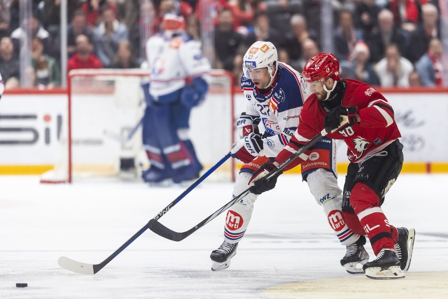 Derek Grant (ZSC), left, vies for the puck with Andrea Glauser (LHC), right, during the first leg of the National League Swiss Championship final playoff game between Lausanne HC, LHC, and ZSC Lions,  ...