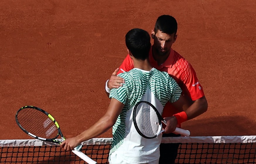 epa10681956 Novak Djokovic of Serbia (back) reacts with Carlos Alcaraz of Spain after winning their Men&#039;s semi final match during the French Open Grand Slam tennis tournament at Roland Garros in  ...