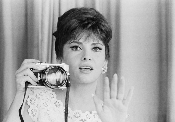 Italian movie star Gina Lollobrigida shows a 0.95 super-grand-angle lens mount on a 35mm camera, as she presents her collection of photographic equipment at her home on the ancient Appian Way on the o ...