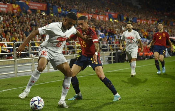 Switzerland's Dan Ndoye, left, challenges for the ball with Spain's Yeremy Pino during the UEFA Nations League soccer match between Spain and Switzerland, at the Benito Villamarin Stadium, in Seville, ...