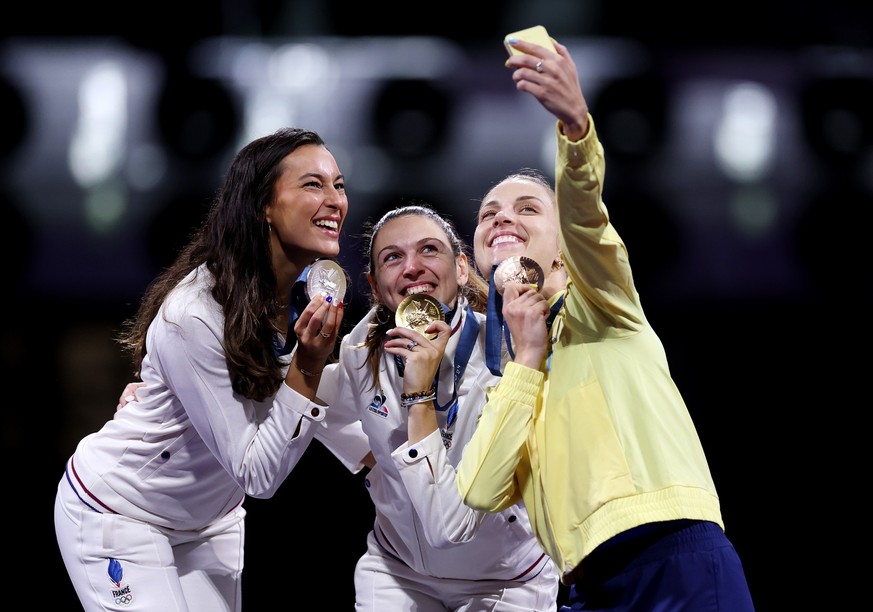 PARIS, FRANCE - JULY 29: Gold medalist Manon Apithy-Brunet of Team France (C), Silver medalist Sara Balzer of Team France (L) and Bronze medalist Olga Kharlan of Team Ukraine (R) take a selfie on the  ...