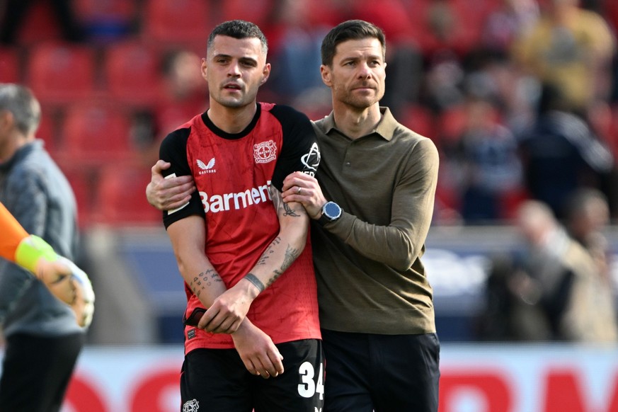 26.04.2025, Nordrhein-Westfalen, Leverkusen: Fu�ball: Bundesliga, Bayer Leverkusen - FC Augsburg, 31. Spieltag, BayArena, Leverkusens Granit Xhaka und Trainer Xabi Alonso stehen nach dem Spiel auf dem ...