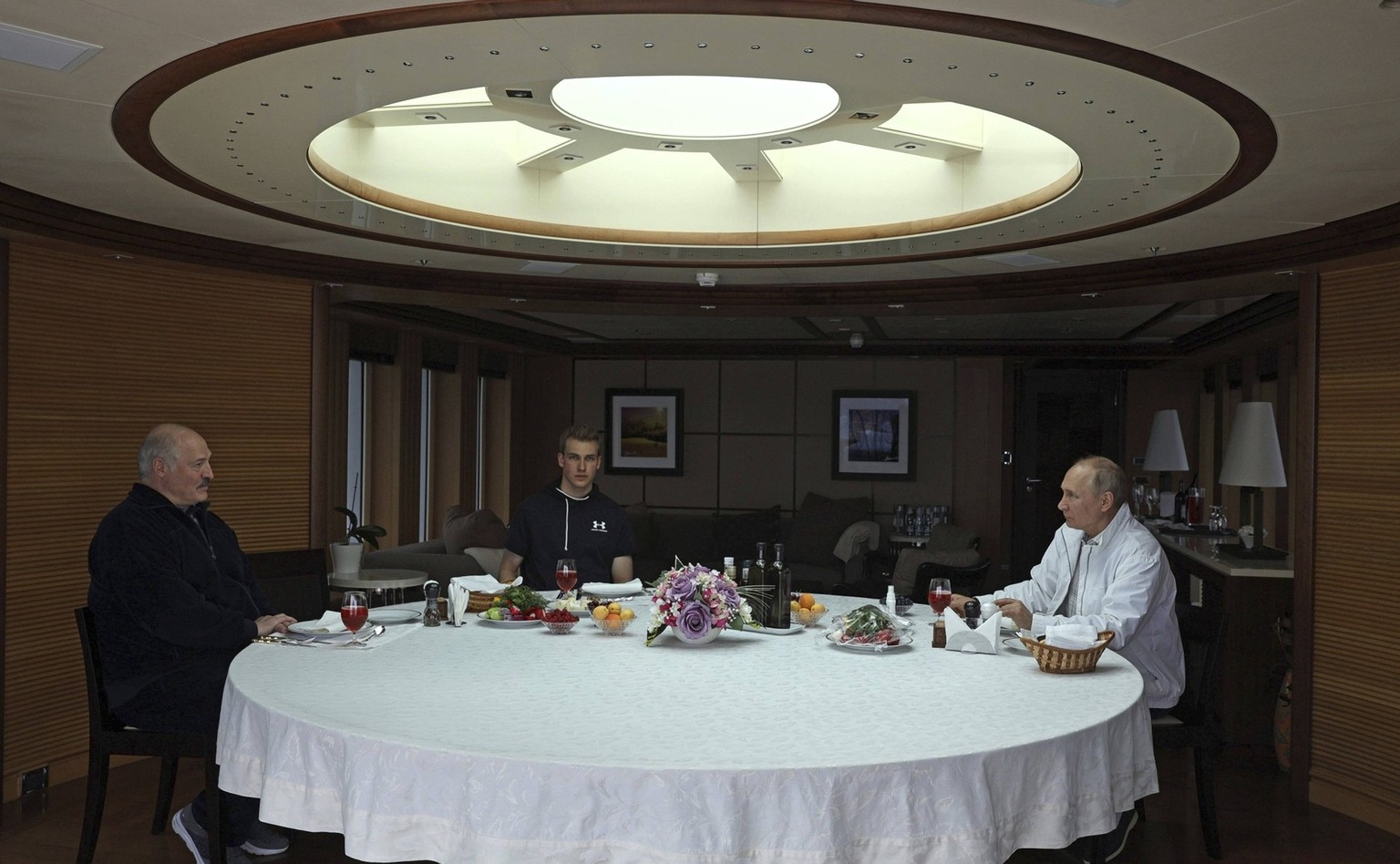 Le président Vladimir Poutine organise un petit-déjeuner pour le président biélorusse Alexandre Loukachenko et son fils Nikolaï Loukachenko, au centre, à bord d&#039;un yacht sur la mer Noire.