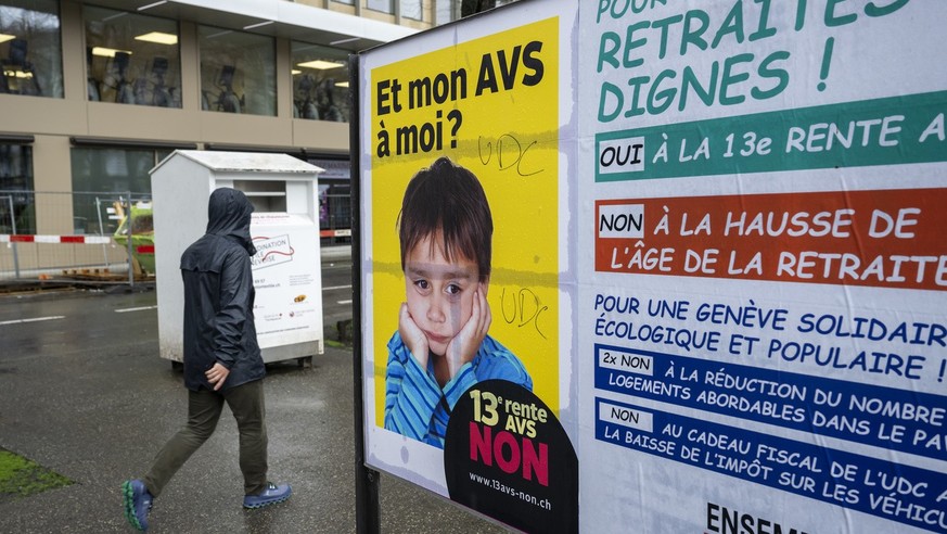 Un personne passe devant des affiches des partis politiques et des associations donnant leurs mots d&#039;ordre pour les votations federales et cantonales du 3 mars, ce jeudi 22 fevrieir 2024 a Geneve ...