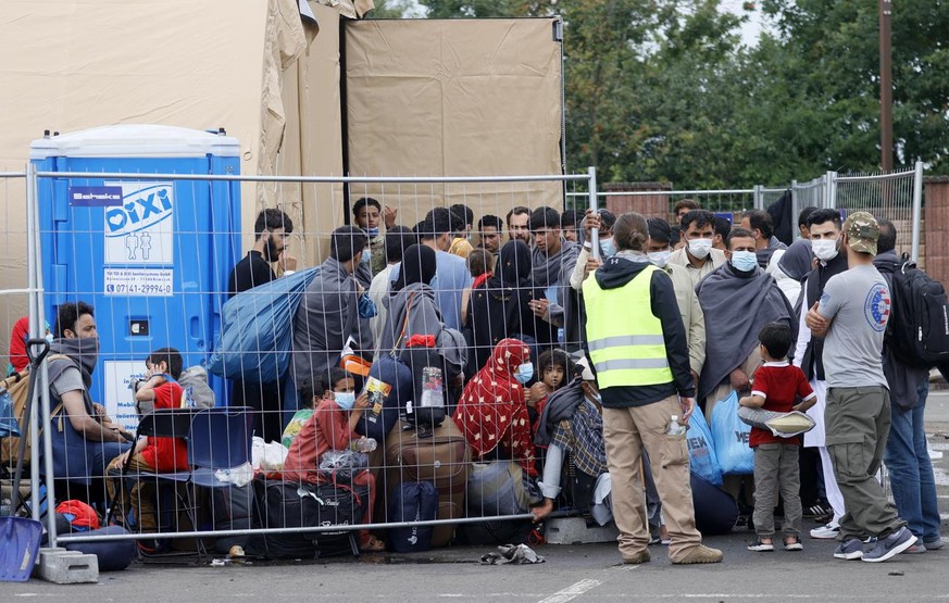 epa09436909 Evacuees from Afghanistan wait at the US Air Base in Ramstein, Germany, 30 August 2021. Ramstein Air Base is serving as major hub in the operation to evacuate people from Afghanistan, as t ...