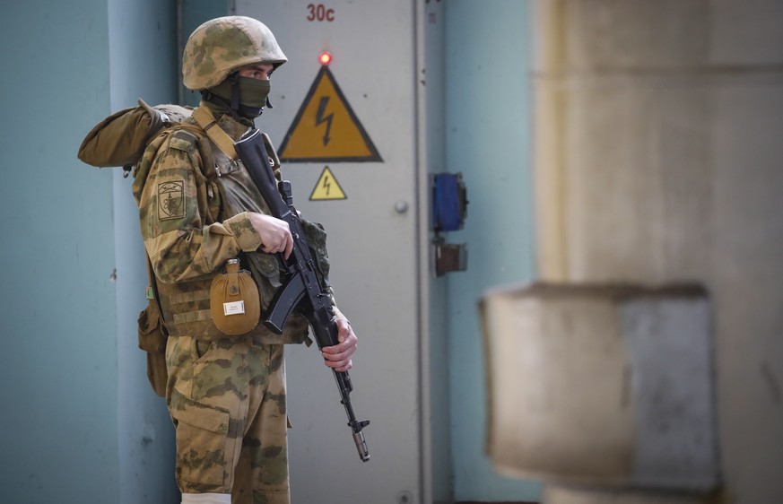 epa09962118 A picture taken during a media tour organized by the Russian Army shows a Russian serviceman standing guard inside the Kakhovka Hydroelectric Power Plant (HPP) on the Dnieper River in Kakh ...