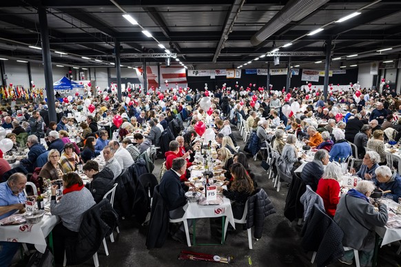 Des personnes mangent et fetent au Forum de l'Arc pendant le repas du grand banquet lors des festivites marquant le changement de canton de la ville de Moutier le mercredi 31 decembre 2025 a Mout ...