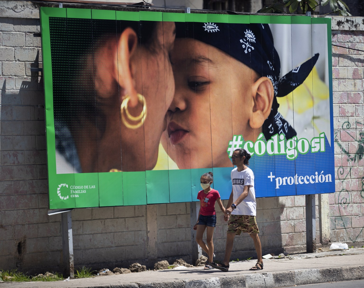 epa10204258 A man and a child walk past a banner that is part of the &#039;Yes&#039; campaign in the referendum on the family code, in Havana, Cuba 24 September 2022. More than eight million Cubans ar ...