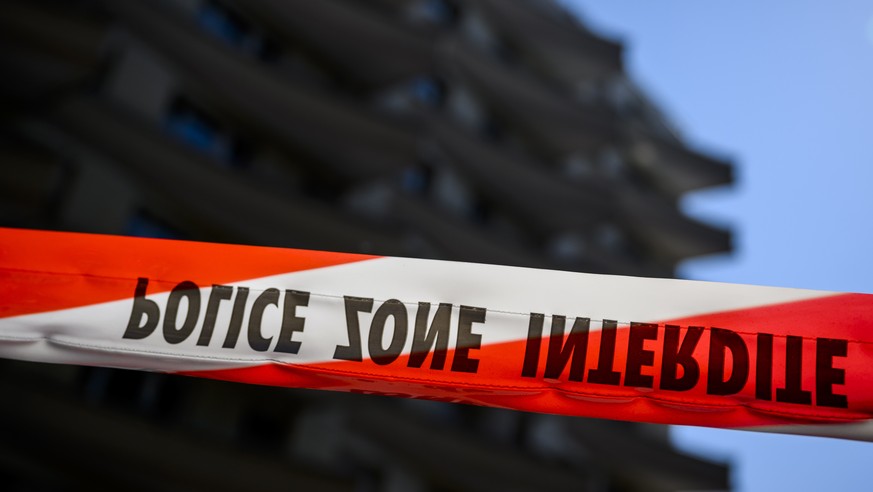 epa09846343 A ribbon of the Vaud cantonal police is visible in front of the scene of the tragedy where four people were found dead and one seriously injured at the foot of a building after reportedly  ...