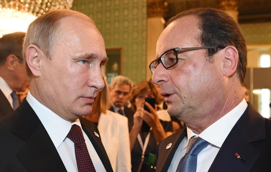 epa04450463 Russian President Vladimir Putin (L) and French President Francois Hollande speak on the sidelines of the ASEM summit in Milan, northern Italy, 17 October 2014. Russian President Vladimir  ...