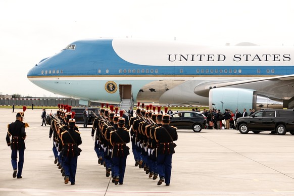 epa11390978 Members of the French Republican Guard (front) get ready as the Air Force One plane carrying US President Joe Biden makes its landing at Paris Orly airport, near Paris, France, 05 June 202 ...