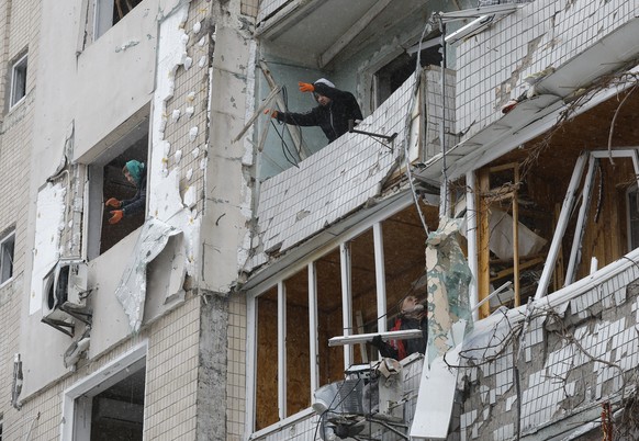 epa11055045 Locals remove debris from their flats at the site of a damaged building a day after a missile strike, in Kyiv (Kiev), Ukraine, 03 January 2024, amid the Russian invasion. At least 27 peopl ...