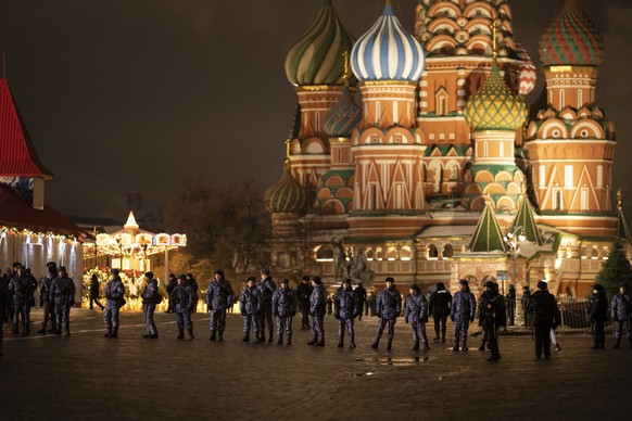 Police and the Rosguardia (National Guard) servicemen walk in the Red Square, closed for celebrations on the New Year's Eve, with the St. Basil's Cathedral, in Moscow, Russia, Saturday, Dec. 31, 2022. ...