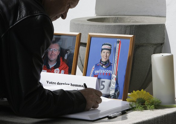 A man signs the book of condolence prior to the funeral service for former Swiss ski racer Corinne Rey-Bellet and her brother Alain at the church of Val d&#039;Illiez, Switzerland, Friday, May 5, 2006 ...