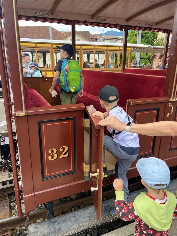 Des enfants prennent place à bord du wagon d'époque de la ligne de chemin de fer du Rigi.