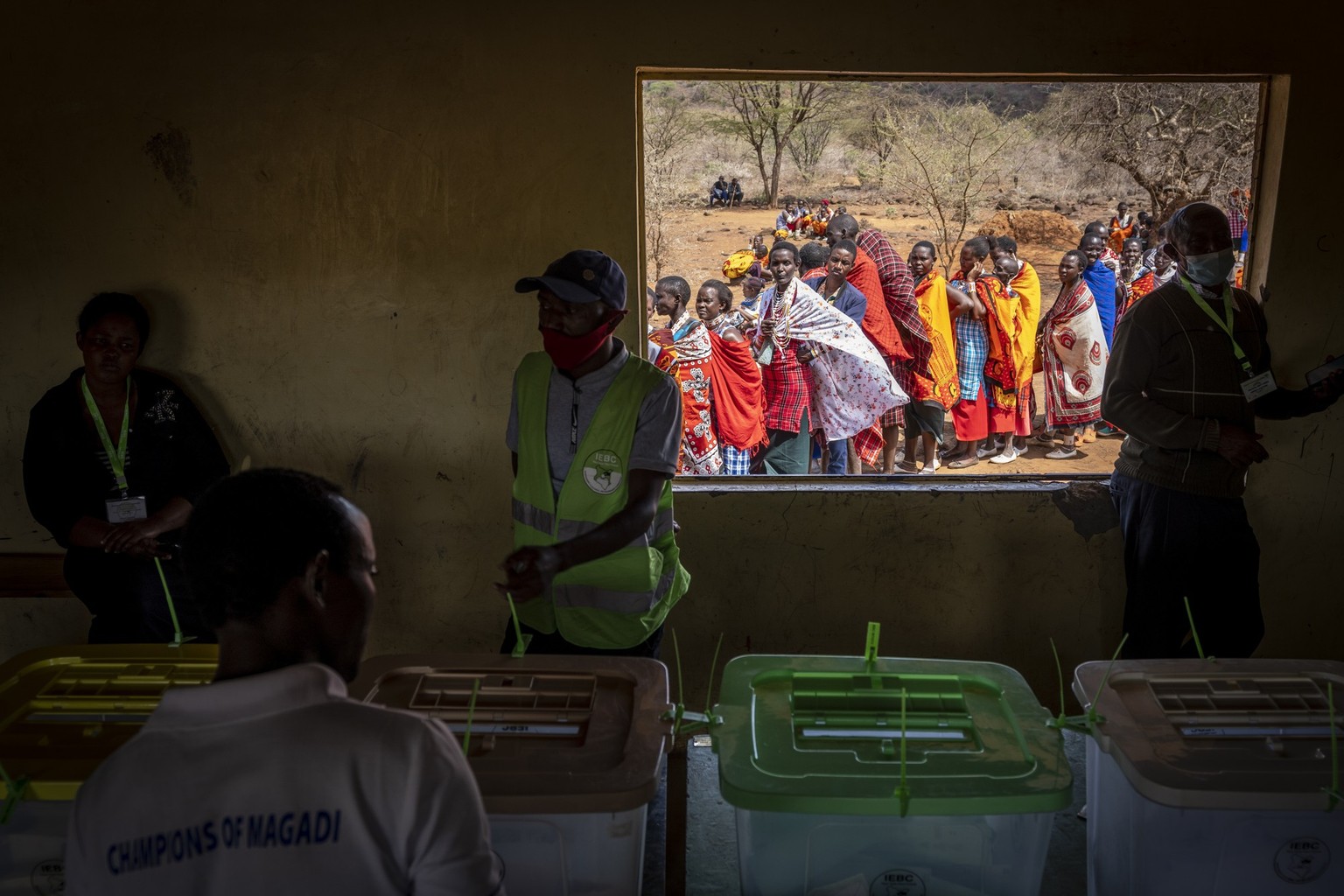 Maasai waiting in line to cast their votes look through an open window at electoral officials inside a polling station at Niserian Primary School, in Kajiado County, Kenya, Tuesday, Aug. 9, 2022. Poll ...