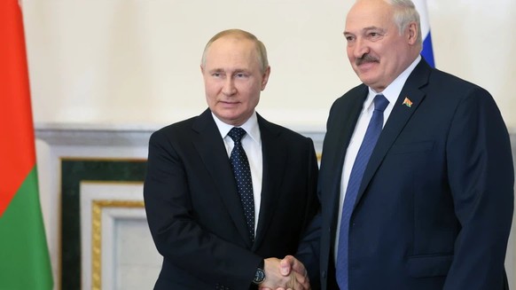 epa10033630 Russian President Vladimir Putin (L) shakes hands with Belarusian President Alexander Lukashenko during their meeting in the Konstantinovsky Palace in St.Petersburg, Russia, 25 June 2022.  ...