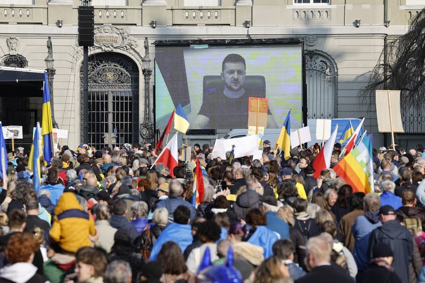Ukrainian President Volodymyr Zelensky is displayed on a screen during a demonstration against the Russian invasion of Ukraine in front of the Swiss parliament building in Bern, Switzerland, Saturday, ...