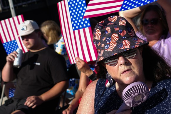 A person cools down with a portable fan ahead of President Donald Trump's speech at the opening of the Great American State Fair on the National Mall, Wednesday, June 24, 2026, in Washington. (AP ...