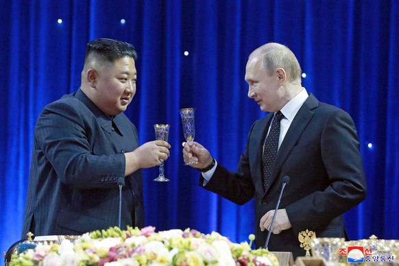 epa07528535 A photo released by the official North Korean Central News Agency (KCNA) shows North Korean leader Kim Jong-un (L) and Russian President Vladimir Putin (R) raising their glasses for a toas ...